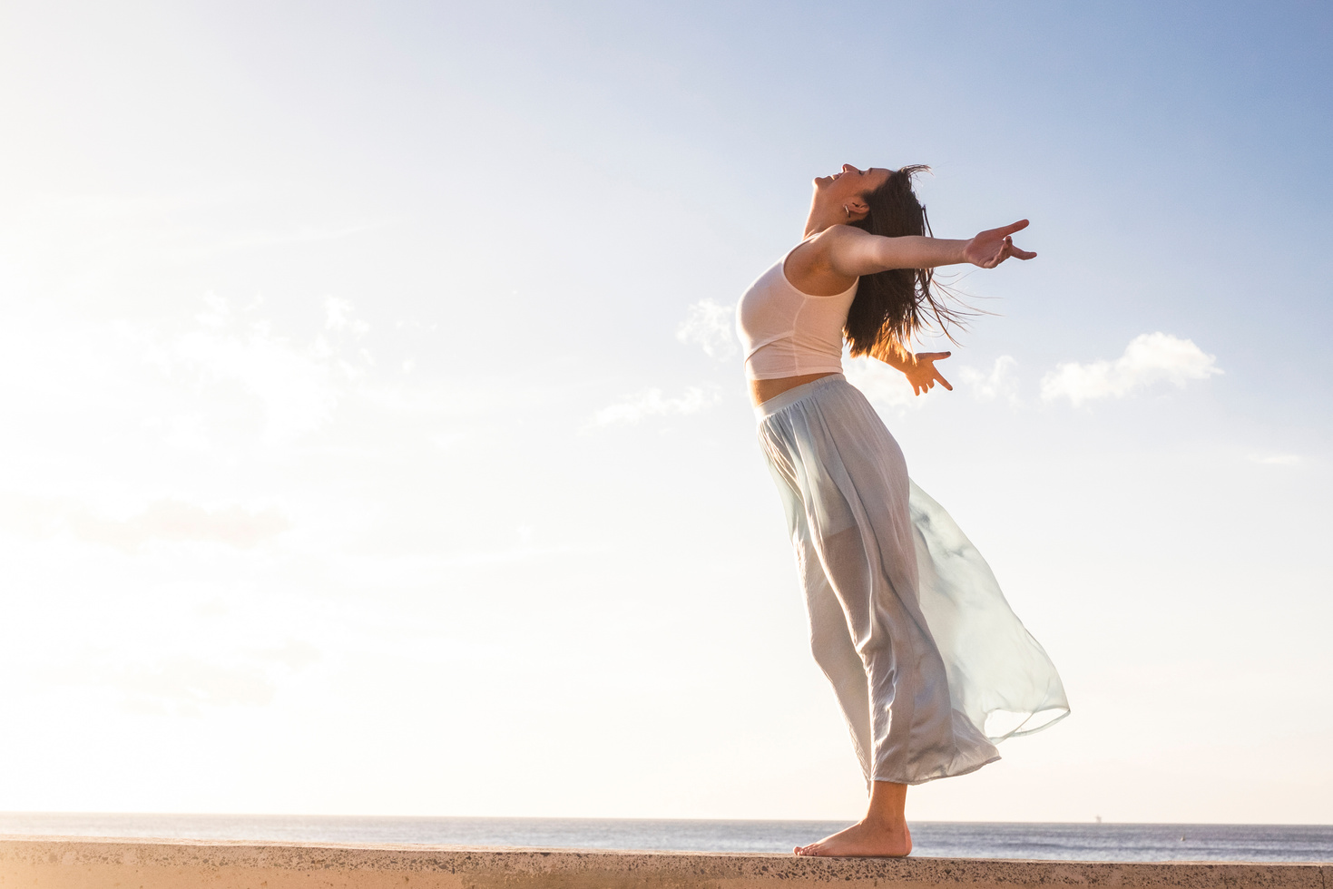 Young Woman Standing on Sky and Sea Background